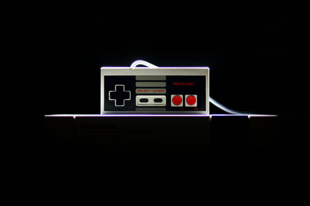 A close-up of a classic NES controller with dramatic lighting on a black background, evoking nostalgia.
