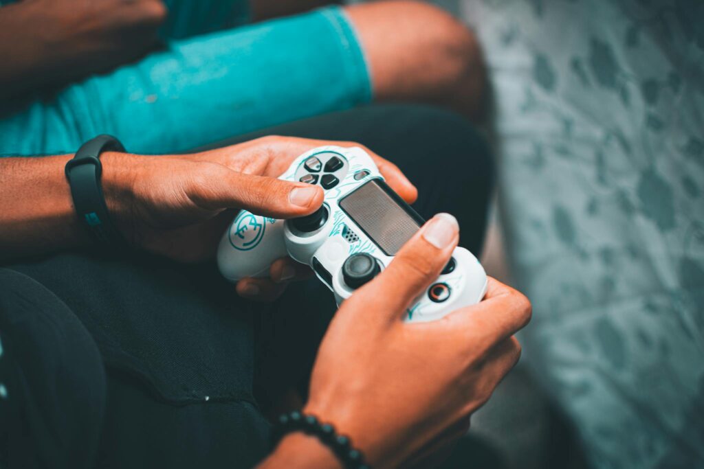 Close-up of hands holding a gaming controller, symbolizing modern gaming culture and leisure.