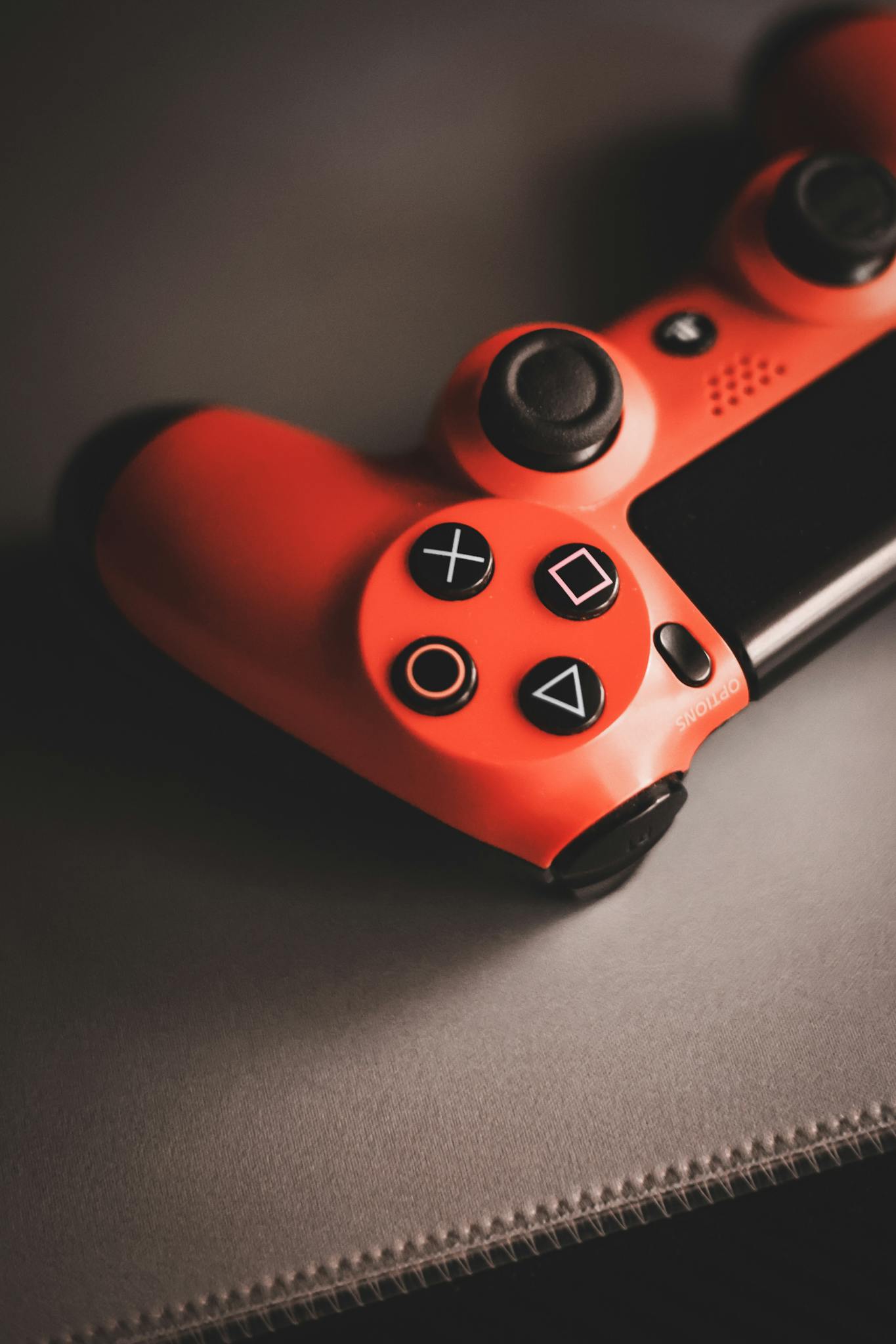 Photo by Ivan Georgiev Red vintage game controller on a surface, showcasing nostalgic gaming design.